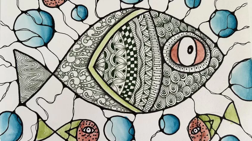 drawing of a fish with multiple patterns through out, blue bubbles and little red fish drawn as well