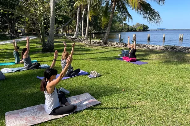 Visitors participate in a yoga class by the Caloosahatchee River. 
