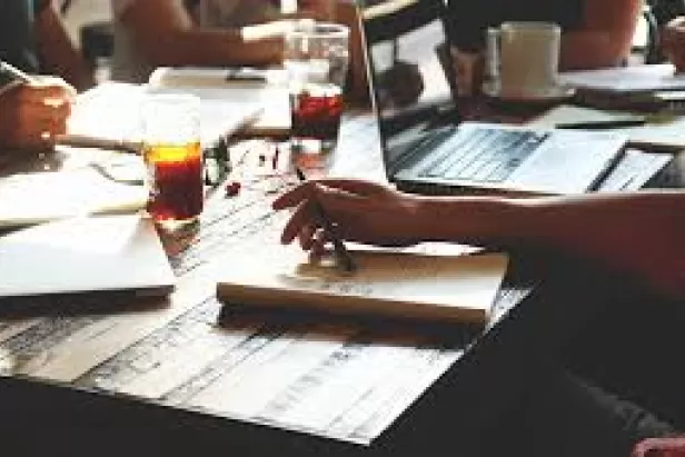 picture of someone sitting at a desk writing
