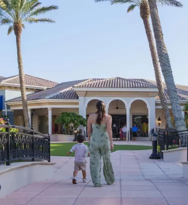 A mother and child walking through an outdoor mall