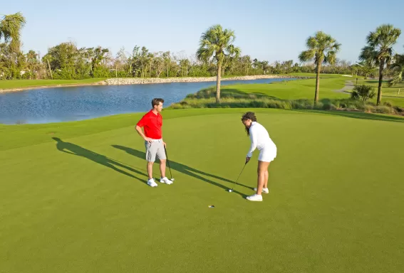 Man and woman playing golf at Bowman's Beach area