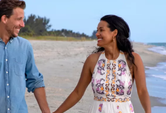 A couple happily walks along the beach