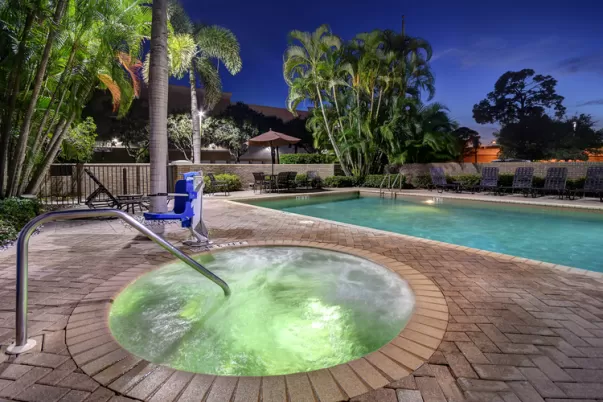 A photo of the pool and hot tub in the evening