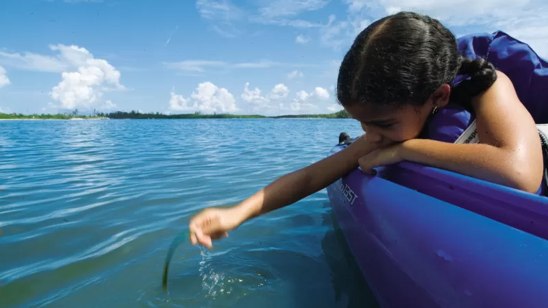 Girl staring into water while kayaking